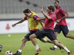 Lionel Messi (izq.) durante el entrenamiento del Barcelona en Seúl. AP  /