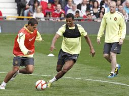 Javier Hernández disputa un balón con Nani, y son observados por Wayne Rooney. AP  /