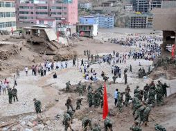 Autoridades y residentes ayudan a rescatar a las víctimas que dejaron atrapadas los deslaves, en el condado de Zhouqu, en China. AP  /