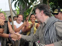 • El presidente de Colombia saluda gente durante una visita a zonas afectadas por el desbordamiento de ríos en la región. EFE  /