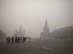 Turistas con cubre-bocas recorren la Plaza Roja, en medio de la contingencia ambiental que ha disparado las enfermedades. AP  /
