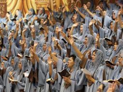 Mujeres fieles a la Luz del Mundo extienden su brazo en señal de saludo. A. CAMACHO  /