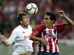 Omar Bravo, de Chivas, disputa el balón con Marcos de Lima, del Internacional. MEXSPORT  /