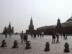 Turistas que caminan por la Plaza Roja tienen un panorama más claro. Meteorólogos advirtieron que podría la polución podría volver. AP  /