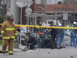 Oficiales y bomberos inspeccionan la zona de la explosión en el complejo de edificios que alberga Caracol Radio y la Agencia EFE. AFP  /