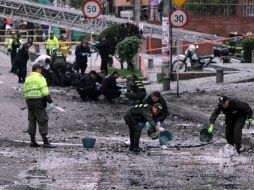 Policías buscan evidencias en el lugar en donde explotó el coche-bomba. Hay 18 personas con heridas leves. EFE  /