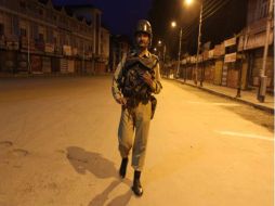 Paramilitares indios patrullan una calle desierta de Srinagar, la capital de verano de la región india de Cachemira. EFE  /