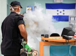 Un oficial de la Policía Nacional fumiga el mosquito que transmite el dengue, en Tegucigalpa. AFP  /