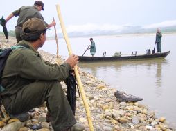 Mis compañeros tharus, armados de sendos garrotes como defensa, en espera del cayuco que nos cruzaría el caudaloso río.P.SOMELLERA  /