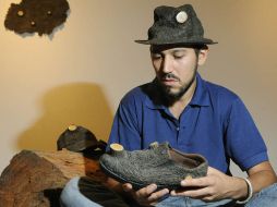 El artista costarricense Sidhartta Mejía posa y exhibe parte de sus creaciones en la exposición. EFE  /