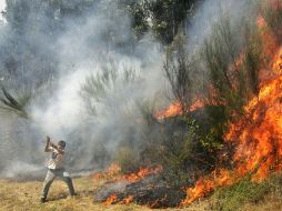 Un hombre ayuda a combatir el incendio en la montaña de Peneda-Gerés, cerca de Pardela, Norte de Portugal. AP  /