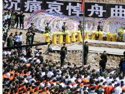 Miles de residentes y rescatistas hacen honores a las personas que perdieron la vida en Zhouqu, Gansu. AFP  /