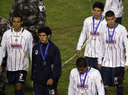 Los jugadores de las Chivas abandonan la cancha del Estadio Beira-Río con la medalla de segundo lugar. AP  /