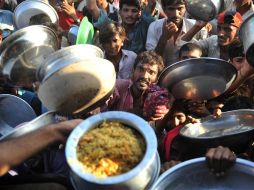 Damnificados paquistaníes se amontonan por recibir un poco de alimento y agua, luego de que las inundaciones los dejarán sin nada. AFP  /