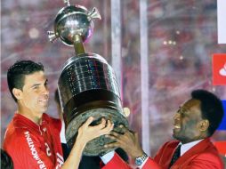 El capitán del Internacional de Porto Alegre, Bolívar, sostiene la Copa junto a Pelé. AFP  /