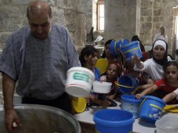 Palestinos esperan por comida que distribuye una agencia humanitaria que apoya el Gobierno jordano. REUTERS  /