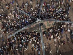 Damnificados por las lluvias esperan por alimentos alrededor de un helicóptero con ayuda humanitaria, en Sindh. AP  /