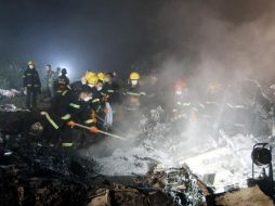Bomberos trabajan en el lugar de la colisión de la aeronave E-190, fabricada por la brasileña Embraer. AP  /