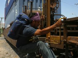 Un hombre que busca llegar a Estados Unidos se trepa a un tren en Hermosillo. REUTERS  /