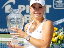Caroline Wozniacki muestra su trofeo ante los fotógrafos. AFP  /