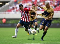 Omar Bravo disputa el balón con Verón de Pumas. E.PACHECO  /