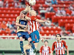 Leandro Augusto (Pumas) y Adolfo Bautista (Chivas) buscan un balón por aire. E. PACHECO  /