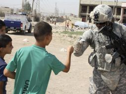 Un soldado estadounidense saluda a niños iraquíes, después de entregarles medicamentos, en Bagdad. REUTERS  /