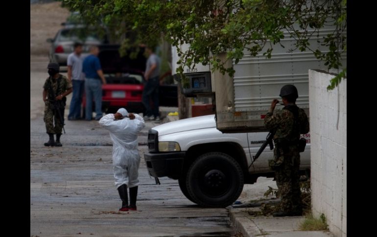Militares vigilan el lugar donde cuerpos de los inmigrantes fueron trasladados para su identificación. AP  /