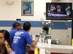 Estadounidenses escuchan el anuncio televisivo en que el presidente Barack Obama anuncia oficialmente el fin de la guerra en Iraq. AFP  /