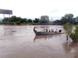 Después del derrumbe del puente viejo el día de ayer, algunas personas cruzaban el río en lancha. ESPECIAL  /