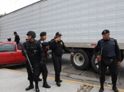 Agentes federales custodian el camión que transporta a 56, de los 72 inmigrantes asesinados en Tamaulipas. EFE  /