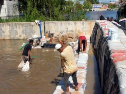Empleados de Obras Públicas de Tabasco levantan muros de costales para evitar más inundaciones en la zona de Villahermosa. NTX  /