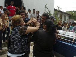 Familiares auxilian a Isabel Carcamo, hija del migrante Miguel Carcamo. Su padre es uno de los 72 ilegales ejecutados en Tamaulipas. AP  /