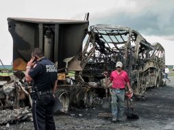 El autobús de pasajeros y el camión calcinados en Oaxaca. AFP  /