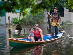 Una familia se moviliza en una canoa debido a las inundaciones por las constantes lluvias en Veracruz. EFE  /