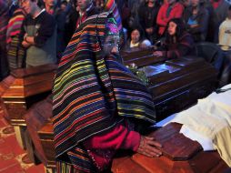 Una mujer llora frente al ataúd de uno de los muertos por las fuertes lluvias que azotan la zona. EFE  /