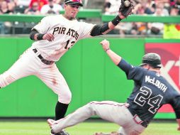 Nate Mclouth, de los bravos, se barre en segunda, ante el intento de Ronnie Cedeño de cazarlo. AP  /