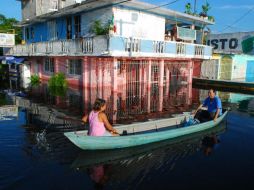 Habitantes de Tabasco navegan en pequeñas embarcaciones sobre lo que fuera una avenida, inundada por desbordamientos de varios ríos.EFE  /