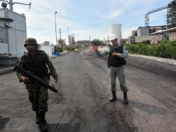 Un elemento del Ejército Mexicano y un guardia de seguridad vigilan la entrada a la refinería de Pemex en Cadereyta. AFP  /