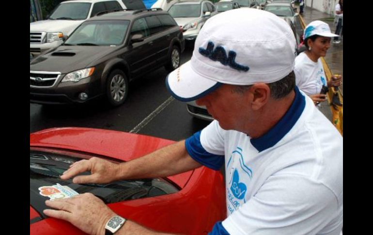 Foto de acción Carlos Andrade Garín pegando una calcamonía de la campaña 'Yo Soy Panamericano'. ARCHIVO  /