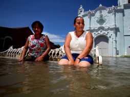 Un par de señoras esperan sentadas a unos familiares en lo que queda de la plazoleta de Tlacotalpan, Veracruz. EL UNIVERSAL  /