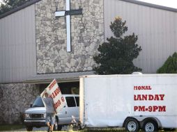 Un hombre retira un cartel que convocaba a los feligreses a participar en el Día Internacional de la Quema del Corán. EFE  /