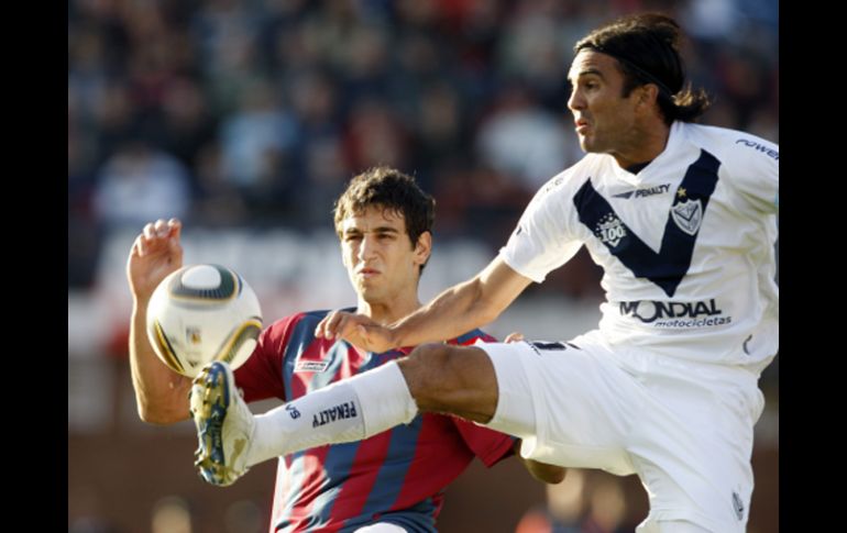 Fabián Cubero (derecha) disputa balón en partido ante San Lorenzo. EFE  /