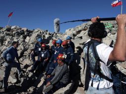 Un reportero entrevista a un equipo de trabajadores que laboran en el rescate de los 33 mineros atrapados en Mina San José. AFP  /