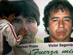 El hijo del minero Esteban Rojas acaricia la fotografía de su padre que se encuentra en una manta gigante. EFE  /