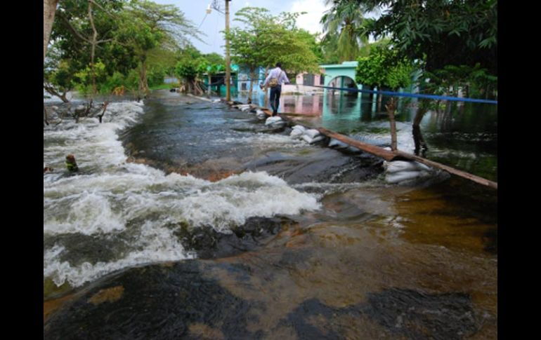 Un vecino hace equilibrio para volver a casa, en Nacajuca, Tabasco. EFE  /