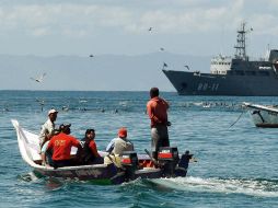 Policías investigadores en la Isla . AP  /
