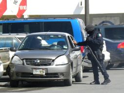 Un policía federal revisa el auto, donde viajaban los dos fotoperiodistas de “El Diario” de Juárez. EL UNIVERSAL  /