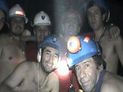 En la fotografía se aprecian a algunos de los 33 mineros cuando saludan hacia la cámara de video. EFE  /