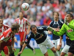 Thomas Mueller (izq.) del Bayern Munich, remata de cabeza ante Sebastian Freis y and Faryd Mondragon del FC Colonia. EFE  /